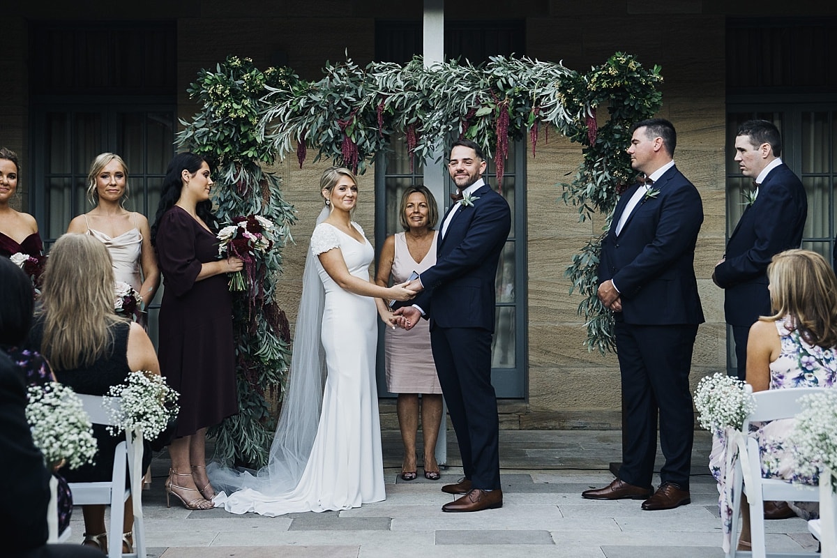 Bride and groom during their wedding ceremony in the sandstone courtyard at Gunners Barracks